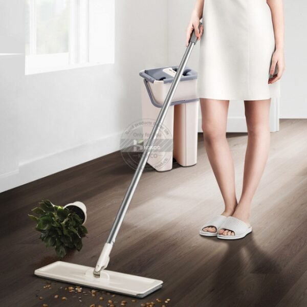 A woman smiling while holding the In and Out 360 Degree Swivel Microfiber Mop in her living room.