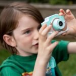 Boy taking picture of the sky with garden scenery.