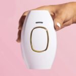 Woman holding IPL laser hair removal device in her hand.