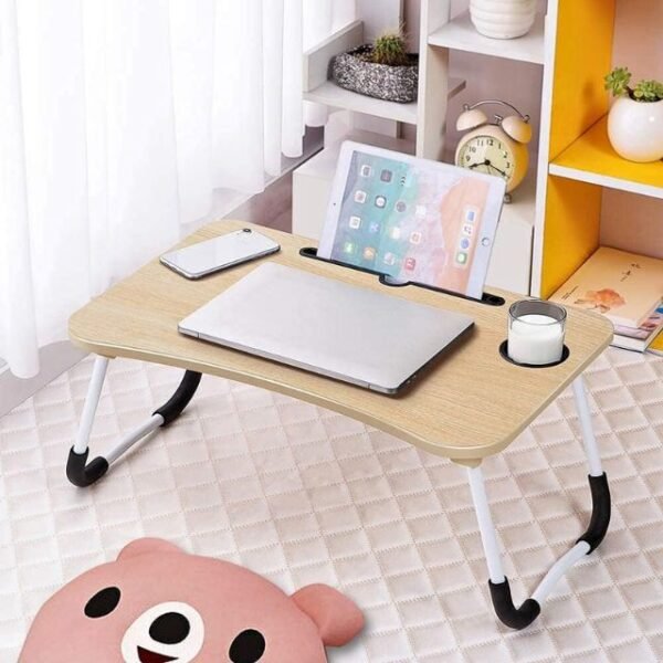 Portable laptop table in cozy bedroom with phone, laptop, tablet, and cup holder.