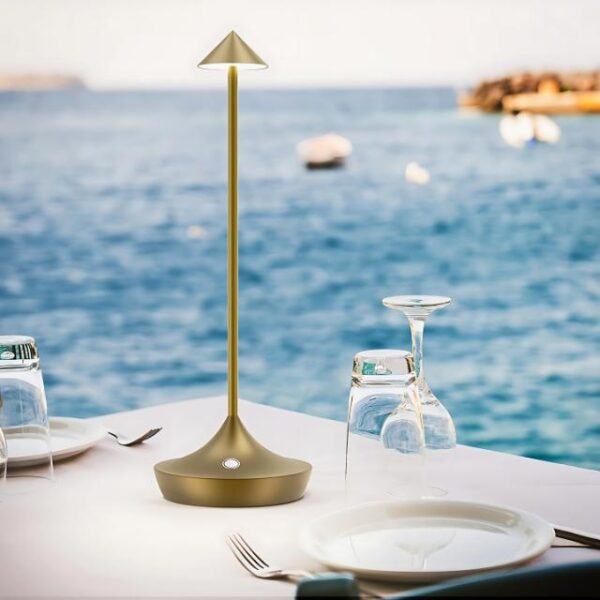 Gold cordless table lamp with dimmer on outdoor dining table.