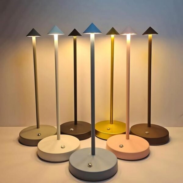 Minimalist table lamps in white, black, coffee, and pink casting warm light.