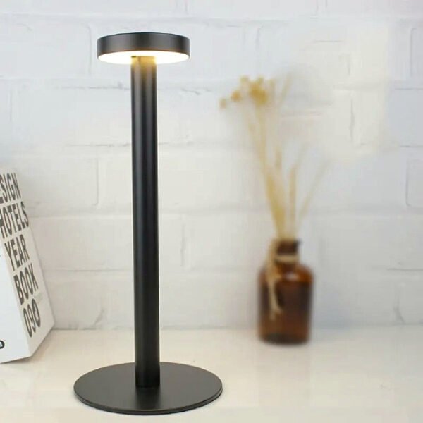 Modern table lamp in black placed in library for stylish home decor.