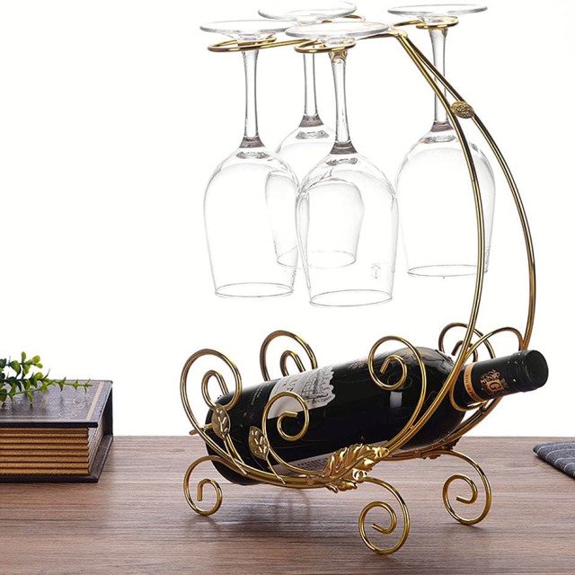 Vintage wine rack in gold for 1 bottle and 4 glasses displayed on table.