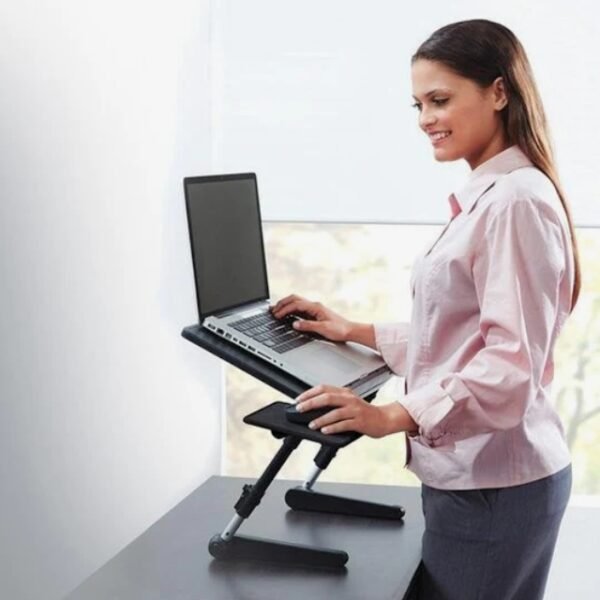 Smiling female worker using Air Space laptop table at the office.