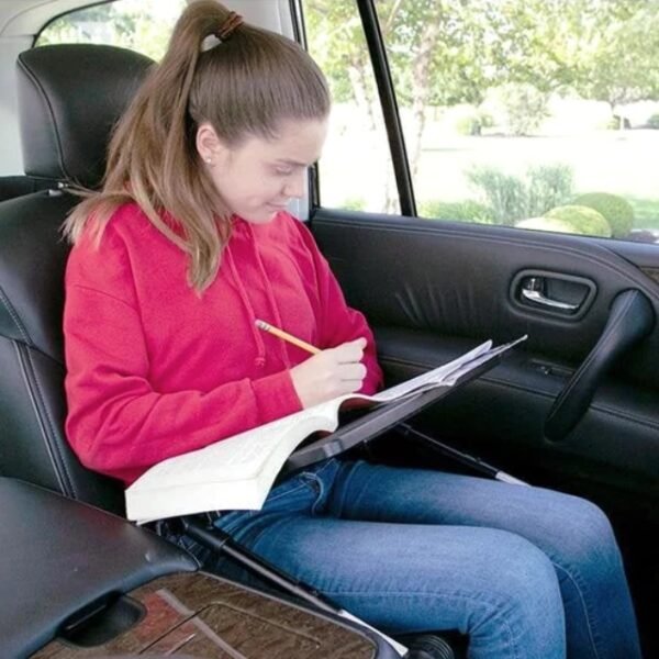 Woman using Air Space laptop table in the car for homework.