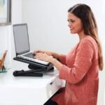 Female typing on laptop with adjustable Air Space laptop table.