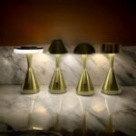 Four bronze table lamps on a marble surface casting light and enhancing decor.