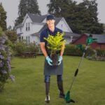 Man happily using CMI Grass Trimmer, enjoying a well-kept garden.