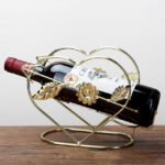 Cupid wine rack on a wooden counter with a gold finish and durable iron.