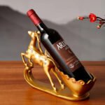 Graceful deer wine rack in gold from the side, holding a bottle at an angle.