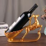 Graceful deer wine rack in gold holding a wine bottle securely.