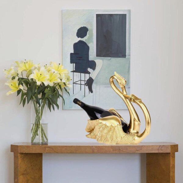 Love swans wine rack in gold on table holding champagne.