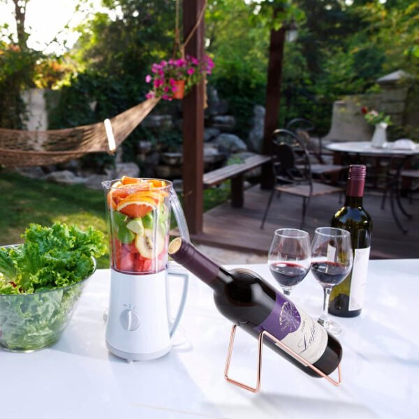 Rose gold minimalist wine bottle holder on an outdoor table.