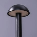 Close-up of mushroom table lamp dome and sleek metallic body.
