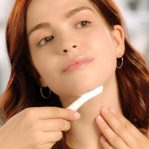 Woman using Flawless Dermaplane Glow to exfoliate her chin area for smooth skin.