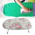 Woman ironing a green t-shirt on Floral Ironing Board.