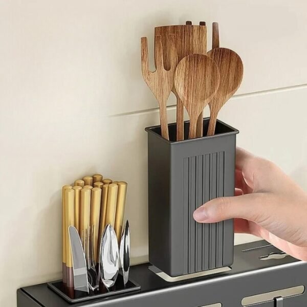 Woman using the kitchen utensil storage rack to store her favorite forks and spatulas—stylish and functional kitchen organization.