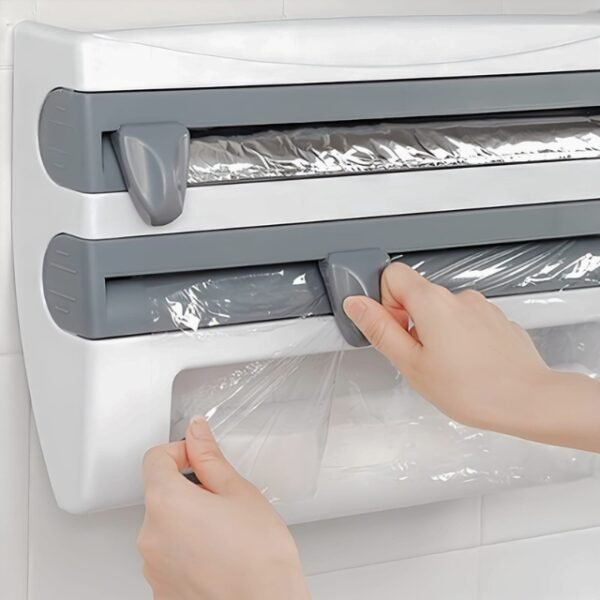 Woman using kitchen paper towel dispenser to cut cling film for cooking.