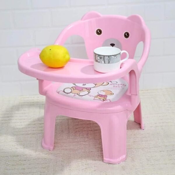 Pink baby high chair on a mattress with a convenient food tray.