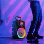 Moxom speaker enhancing party ambience with mic and vibrant lights.