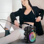 Woman using mic with powerful, compact Moxom wireless speaker.