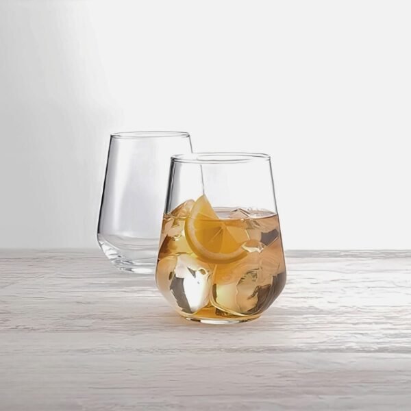 Glass Tumbler Set with Lemon Juice on Wooden Counter.