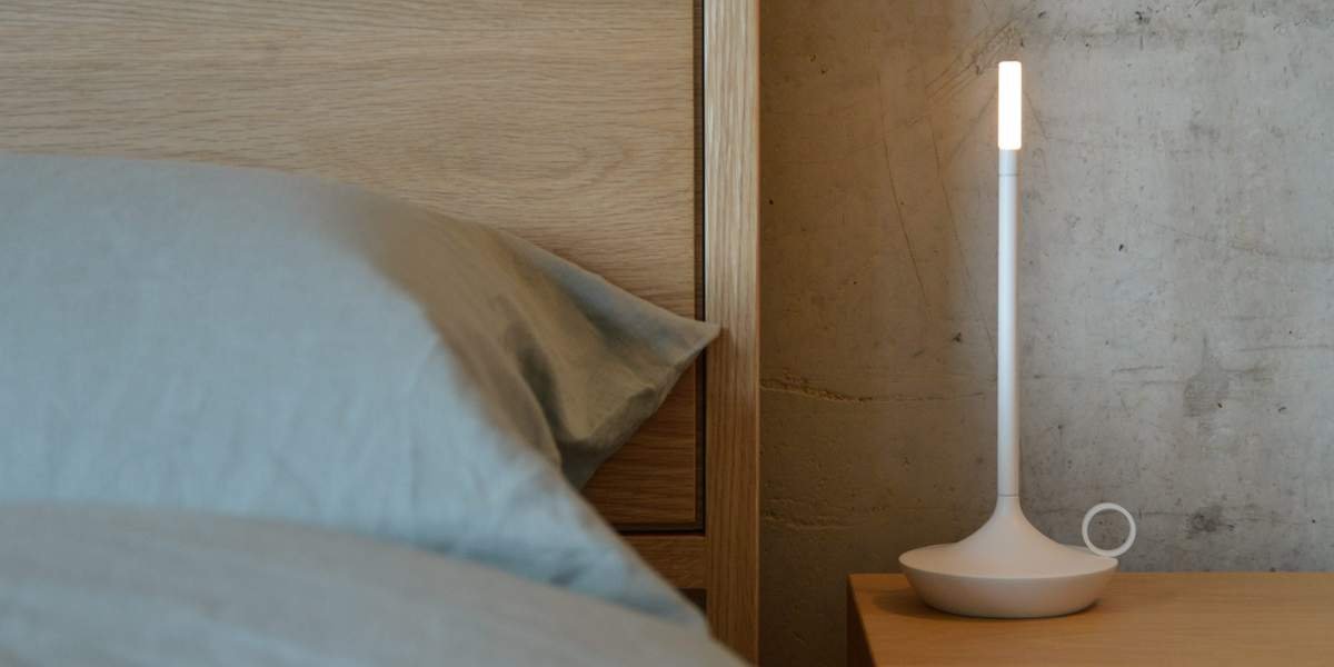 Sleek white Aladdin lamp on bedside table.