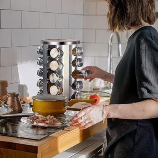 Woman accessing spice jars from the rotating stainless steel and glass spice rack with 20 jars.