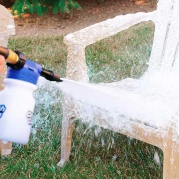 Car wash cannon cleaning garden chairs, splashing away dirt and grime.