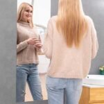 Woman using stick-on plexi mirror with clear view.