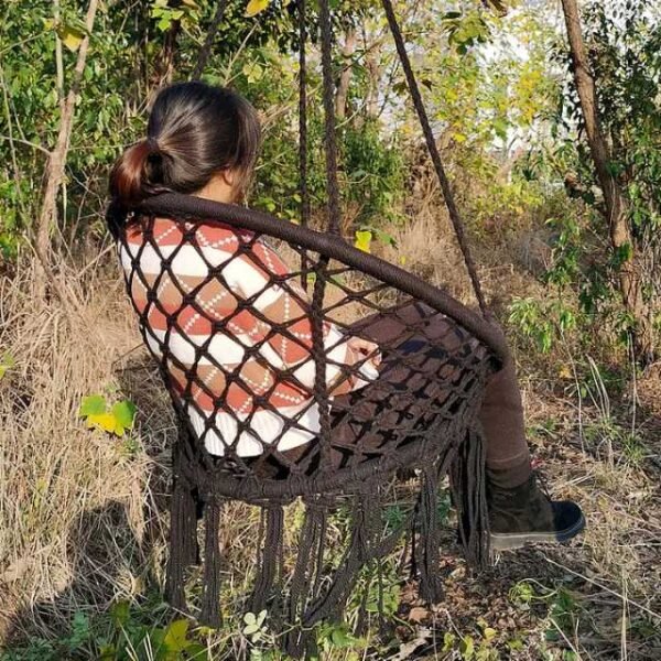 Woman enjoying a camping trip with an outdoor swing hammock chair.