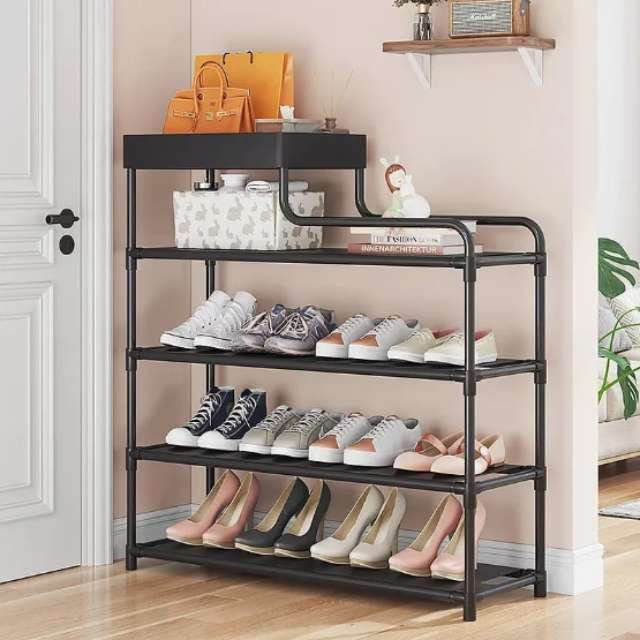 Black 4-layer shoe organizer in home entryway holding shoes.