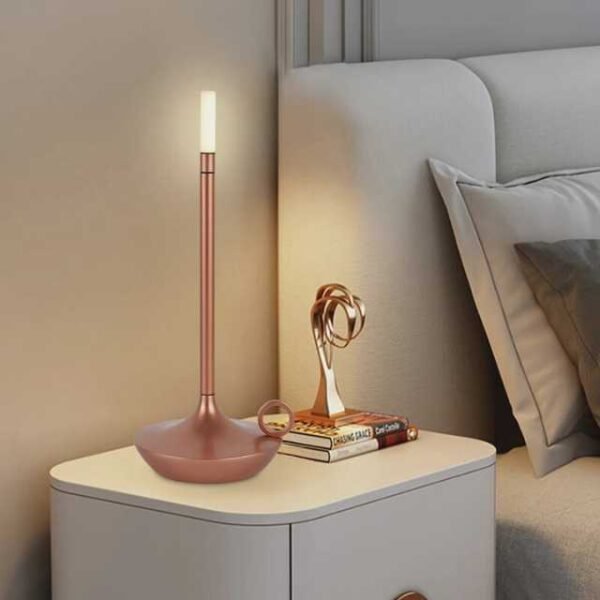 Aladdin table lamp in rose gold on bedside table.