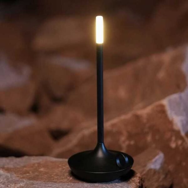 Aladdin table lamp in black casting warm light for home decor.