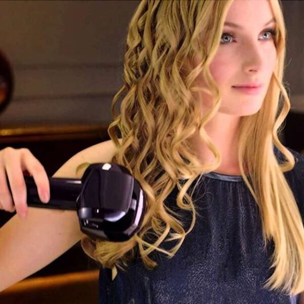 Woman witnessing hair transformation using the Babyliss curling iron.