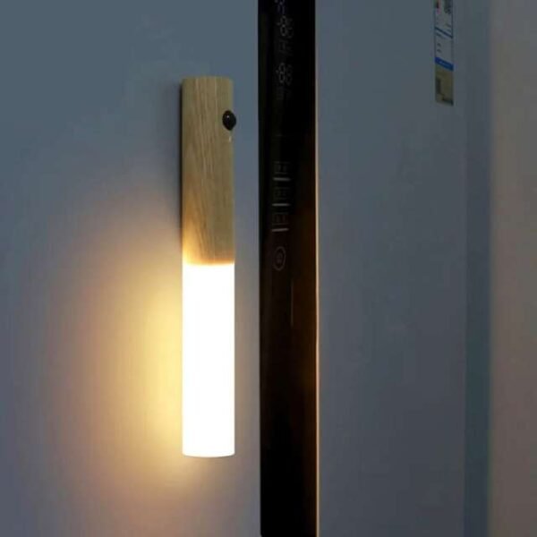 Motion sensor night light mounted on wall, perfect for living room or bedroom settings.