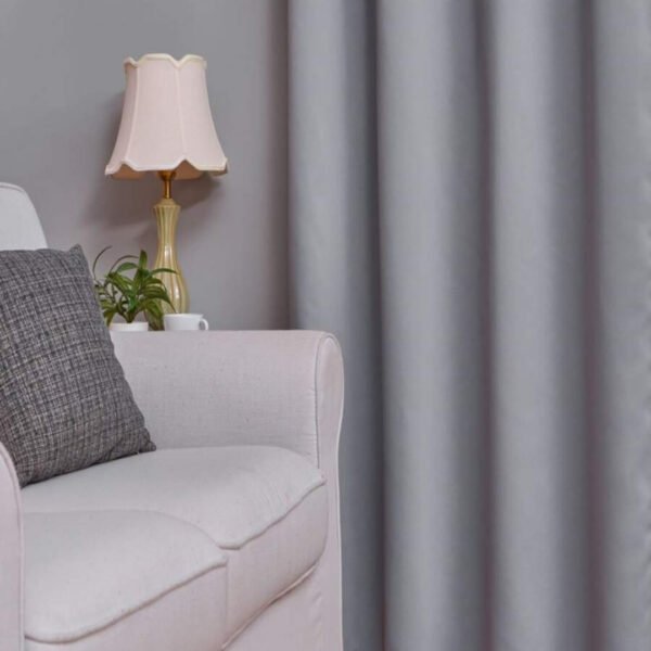 Blackout ring curtain in grey, stylishly placed in a modern bedroom with thermal insulation.