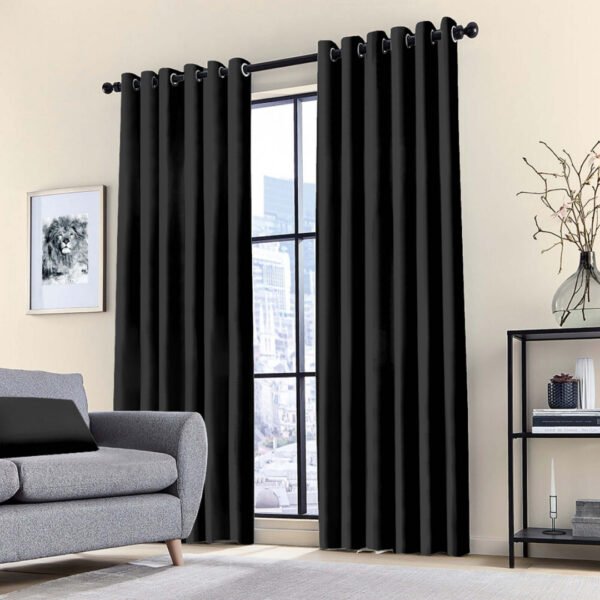 Blackout ring curtain in black, providing thermal insulation and blocking sunlight in a bedroom.