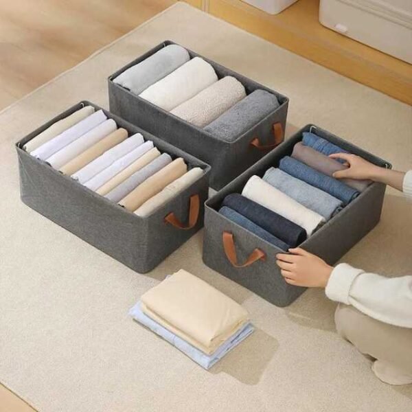 Woman arranging clothes using three foldable storage boxes.