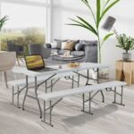 Indoor folding table holding a laptop and snacks.