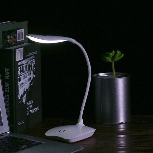 Rechargeable desk lamp in a dim setting for comfortable reading and study.