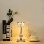 Silver crystal table lamp casting warm light for a cozy reading experience.