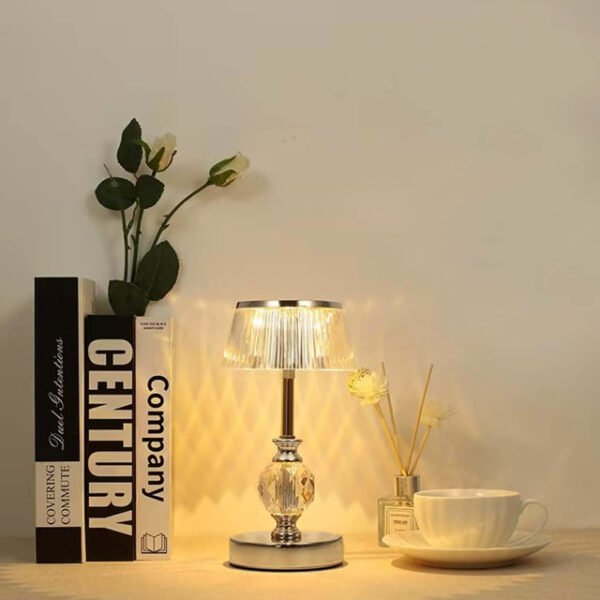 Silver crystal table lamp casting warm light for a cozy reading experience.