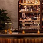 Gold modern table lamps adding ambiance to a bar stand.