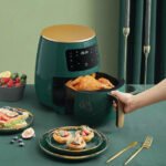 Woman opening 6L drawer of Silvercrest air fryer to retrieve freshly cooked chicken.