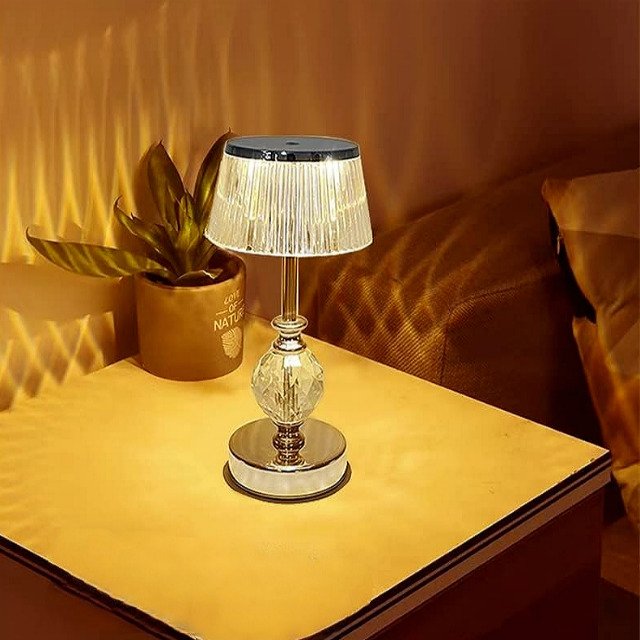 Golden crystal table lamp illuminating a living room with warm light.