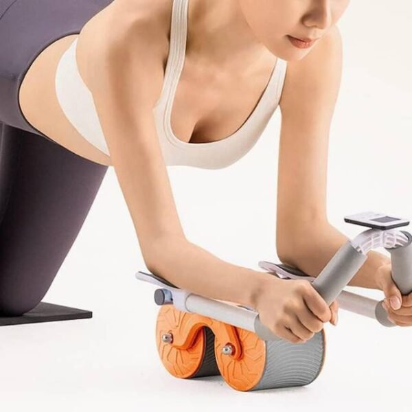 Woman using automatic ab roller with rebound motion and rep counter for core and upper body workout.