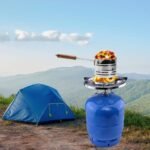 Blue cylinder gas stove heating charcoal, designed for outdoor cooking and camping.
