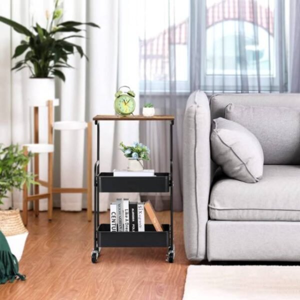 Black storage trolley in living room holding books and decor items neatly.